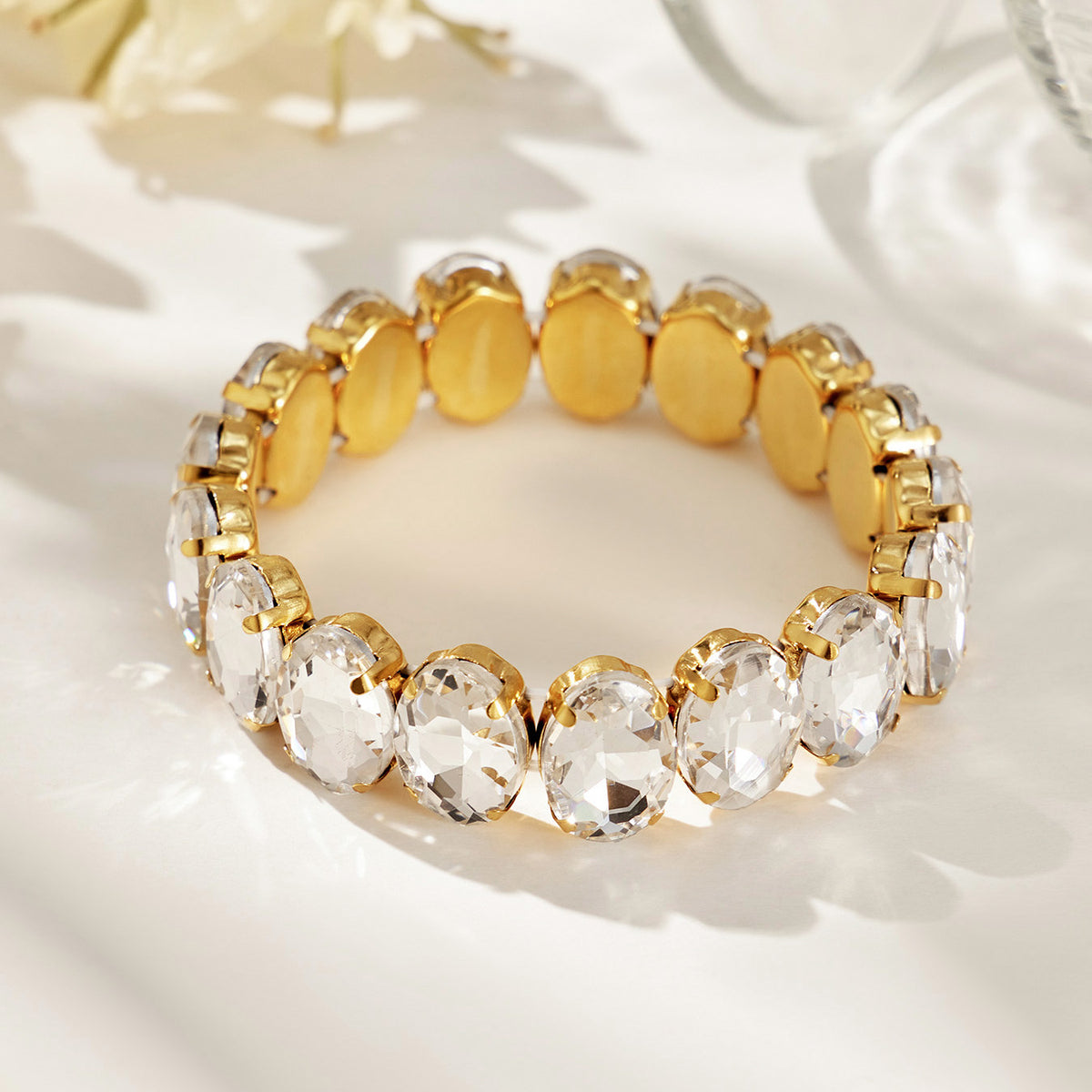 Gold-tone oval glass rhinestone stretch bracelet shown as a single product