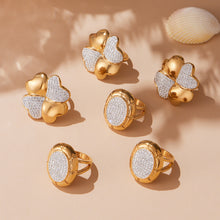 Gold pavé statement rings in round and clover styles arranged together on a neutral display