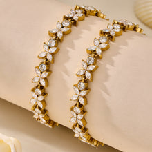 Pair of gold pavé zircon tennis bracelets displayed on soft neutral fabric
