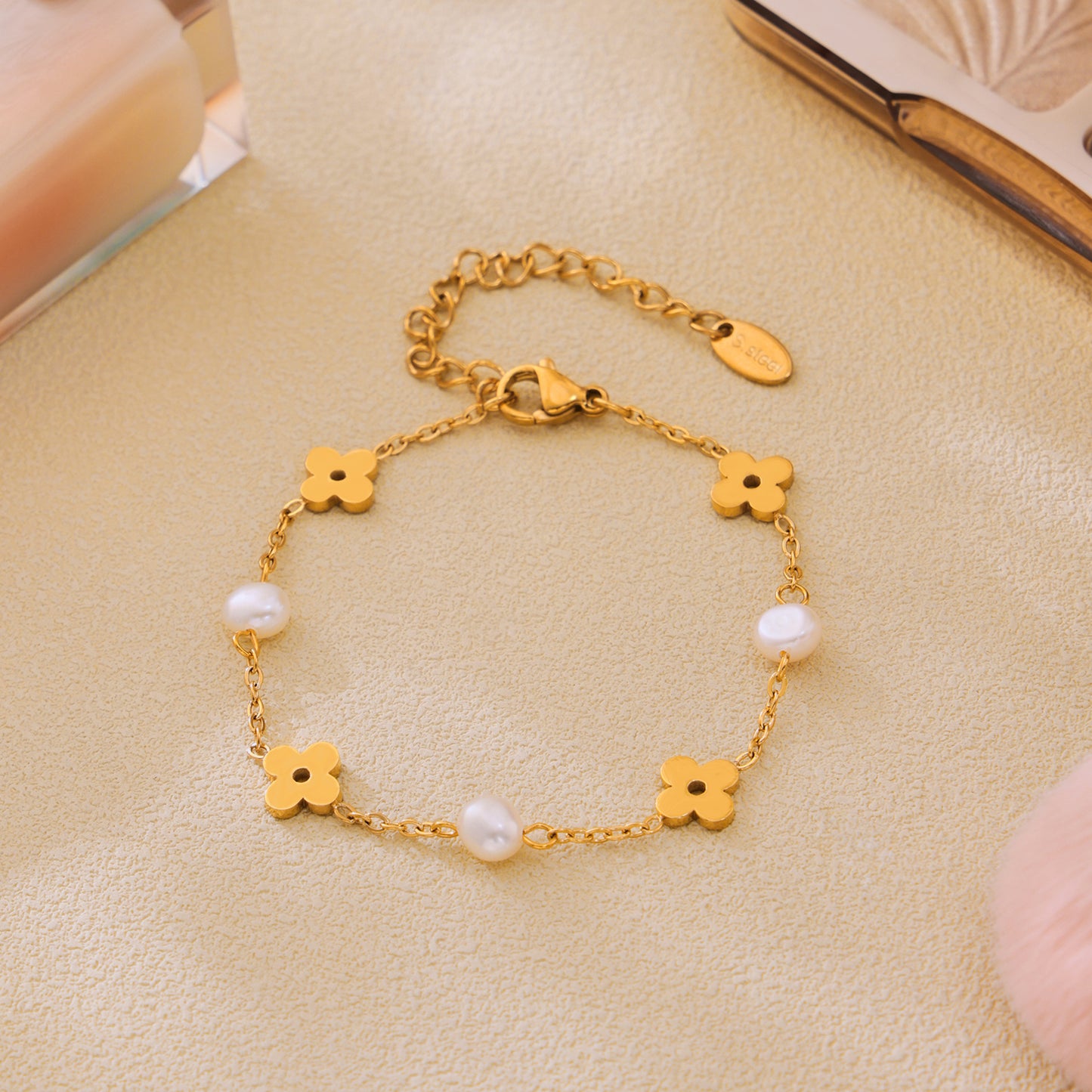 Freshwater pearl clover bracelet displayed flat with polished gold-tone floral details
