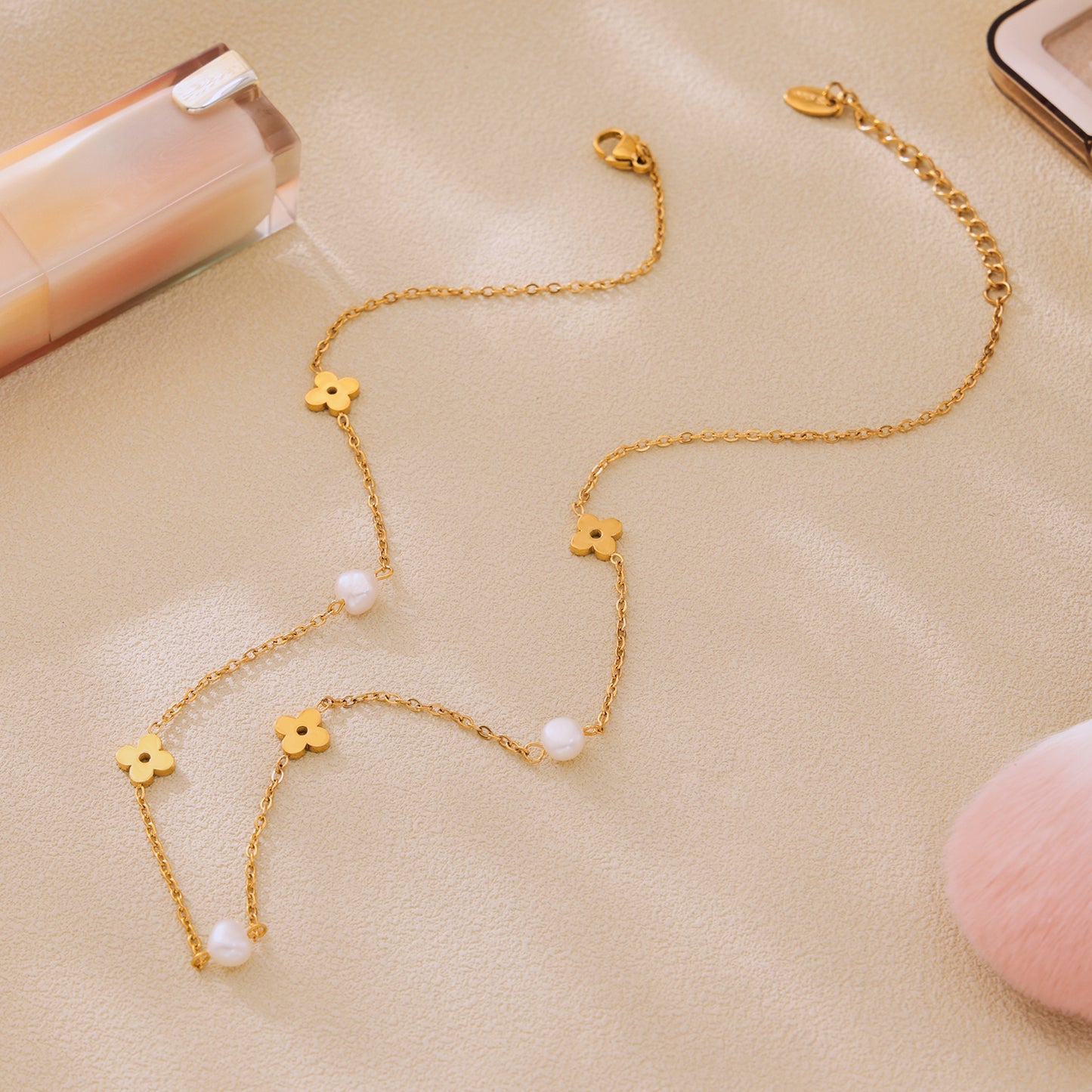 Close-up of a gold clover necklace with freshwater pearl accents and delicate stainless steel chain