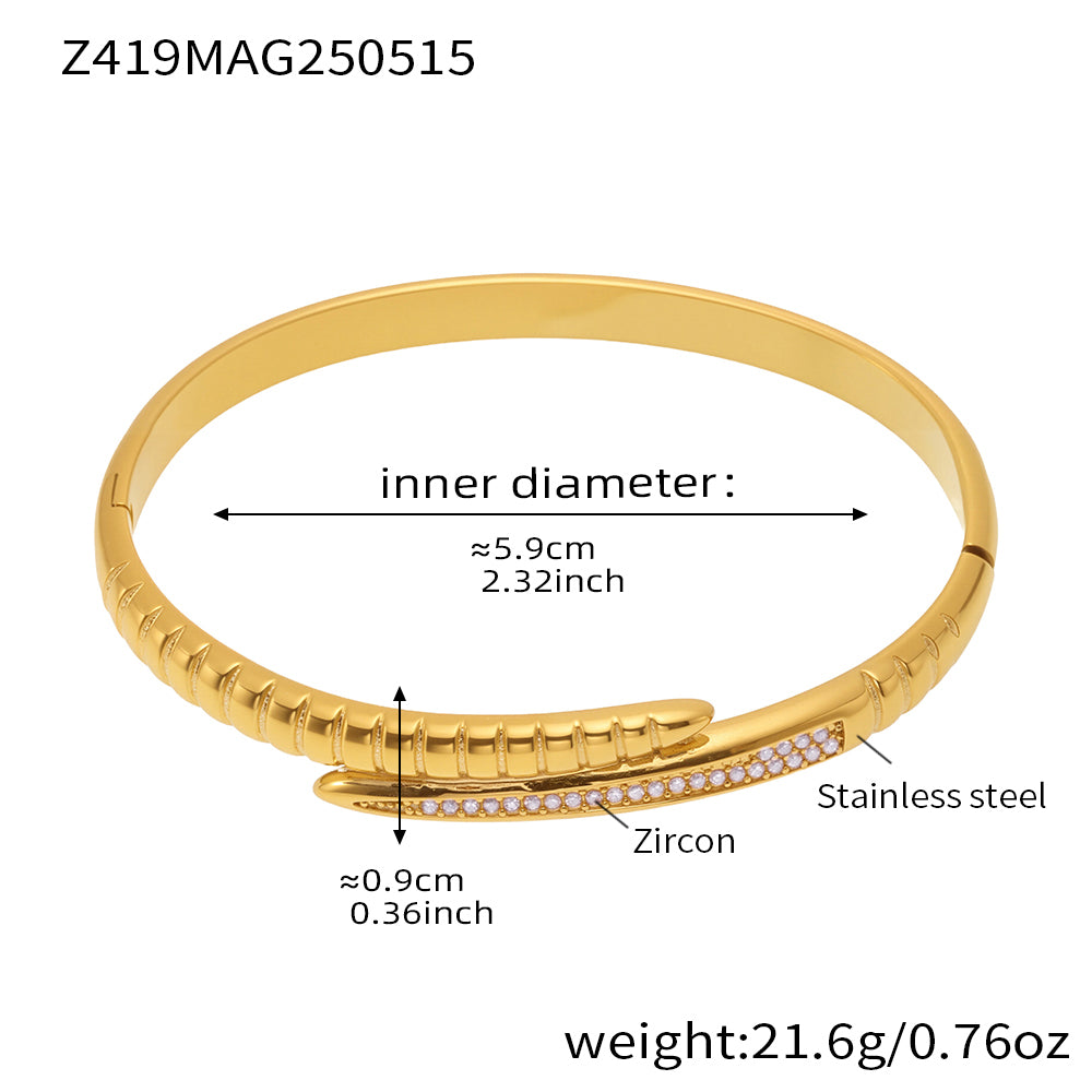 Gold-tone pink zircon nail bangle with a 5.9 cm inner diameter and 21.6 g weight