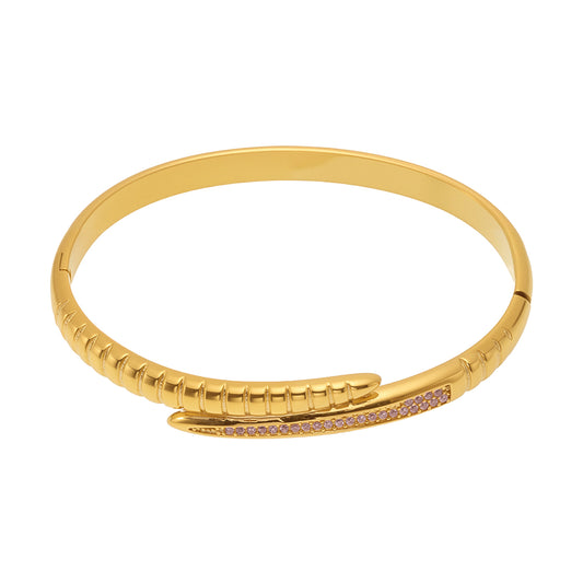 Gold-tone nail bangle bracelet with pink zircon accents on a white background
