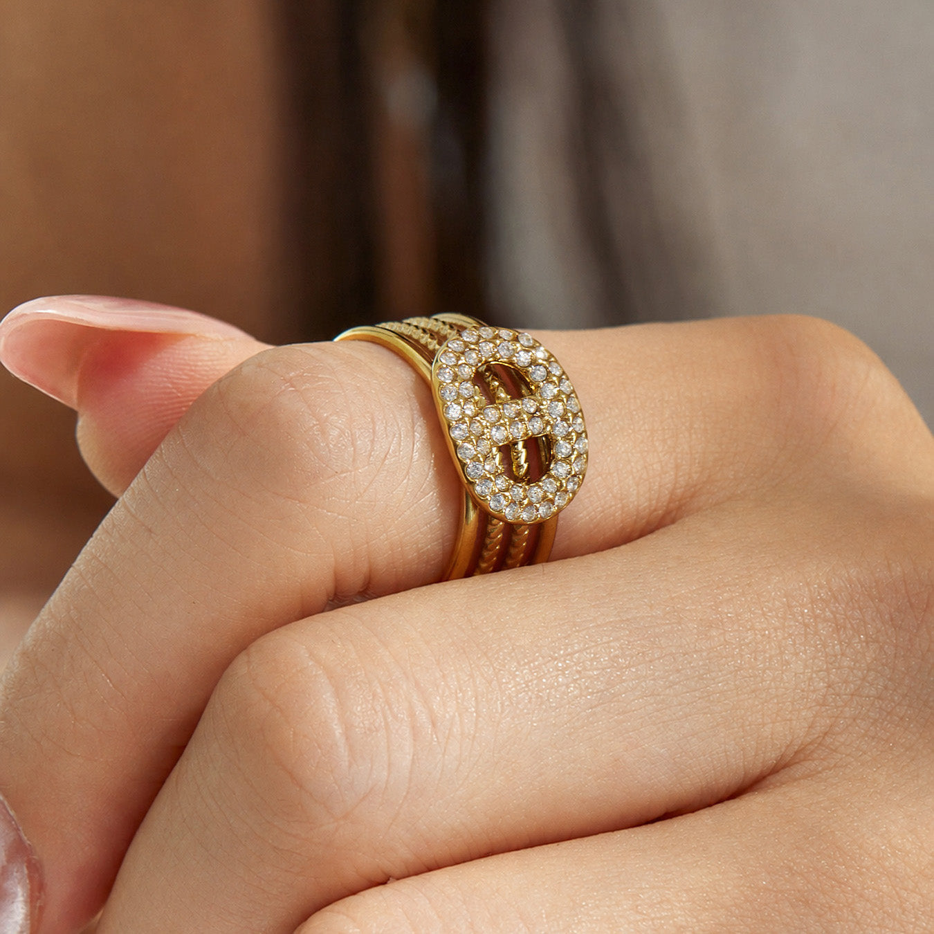 Close-up of a gold rectangular cubic zirconia open ring worn on a model finger
