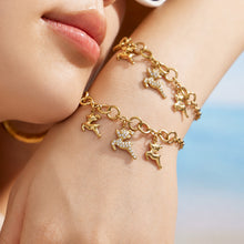 Close-up of a gold reindeer charm bracelet with multiple polished deer pendants