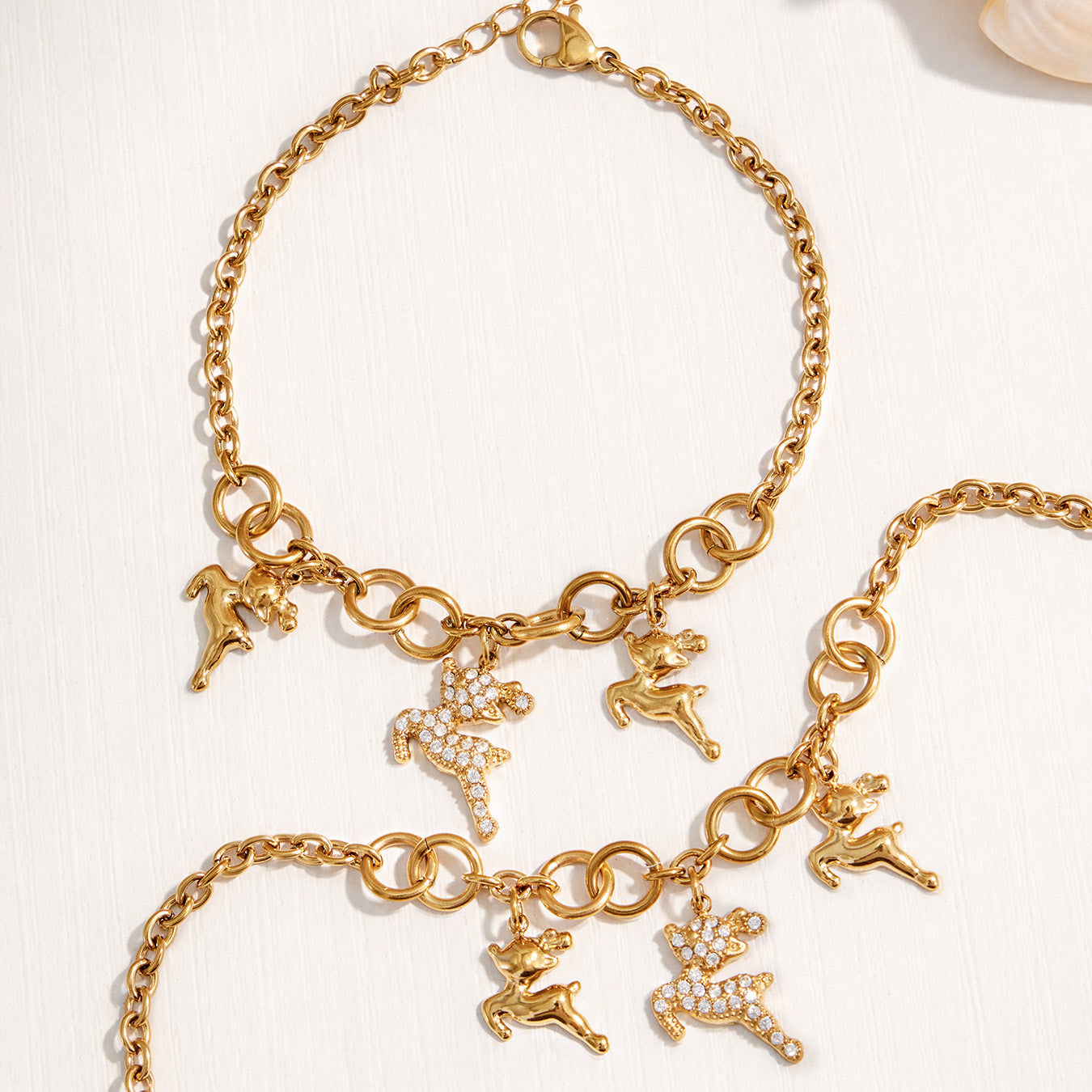 Gold reindeer charm bracelet with a zircon deer centerpiece and adjustable extender chain