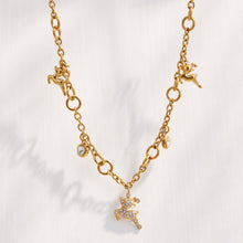 Model wearing a gold reindeer pendant necklace with clear zircon accents