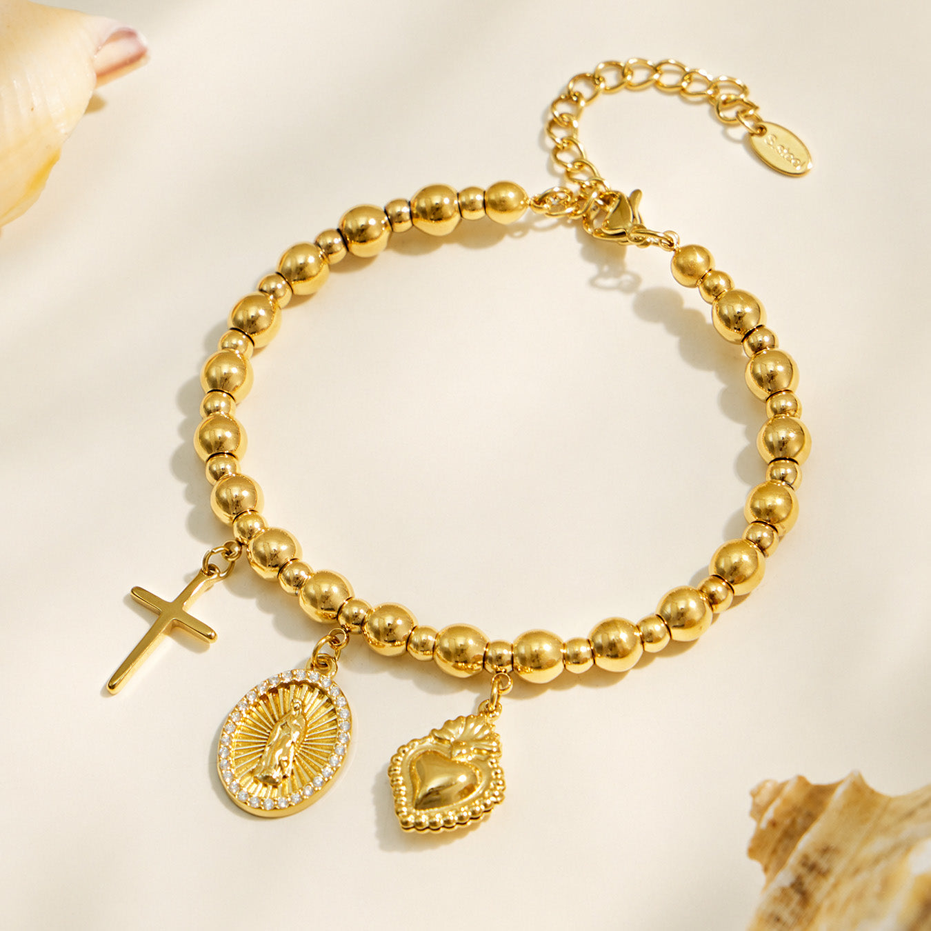 Gold religious charm bracelet with polished beads and three symbolic pendants