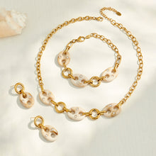 Gold resin mariner link bracelet arranged in a circular flat lay