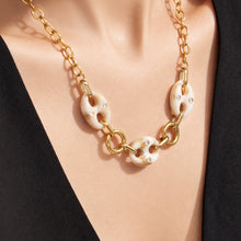 Front view of a model wearing a gold resin mariner link statement necklace