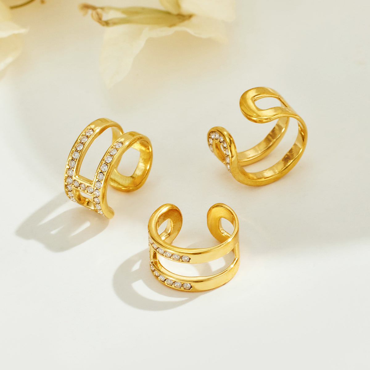 Gold-tone stainless steel rhinestone clip-on ear cuffs displayed as a product assortment