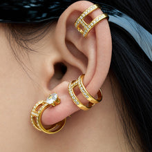 Gold-tone rhinestone clip-on ear cuffs stacked together on ear