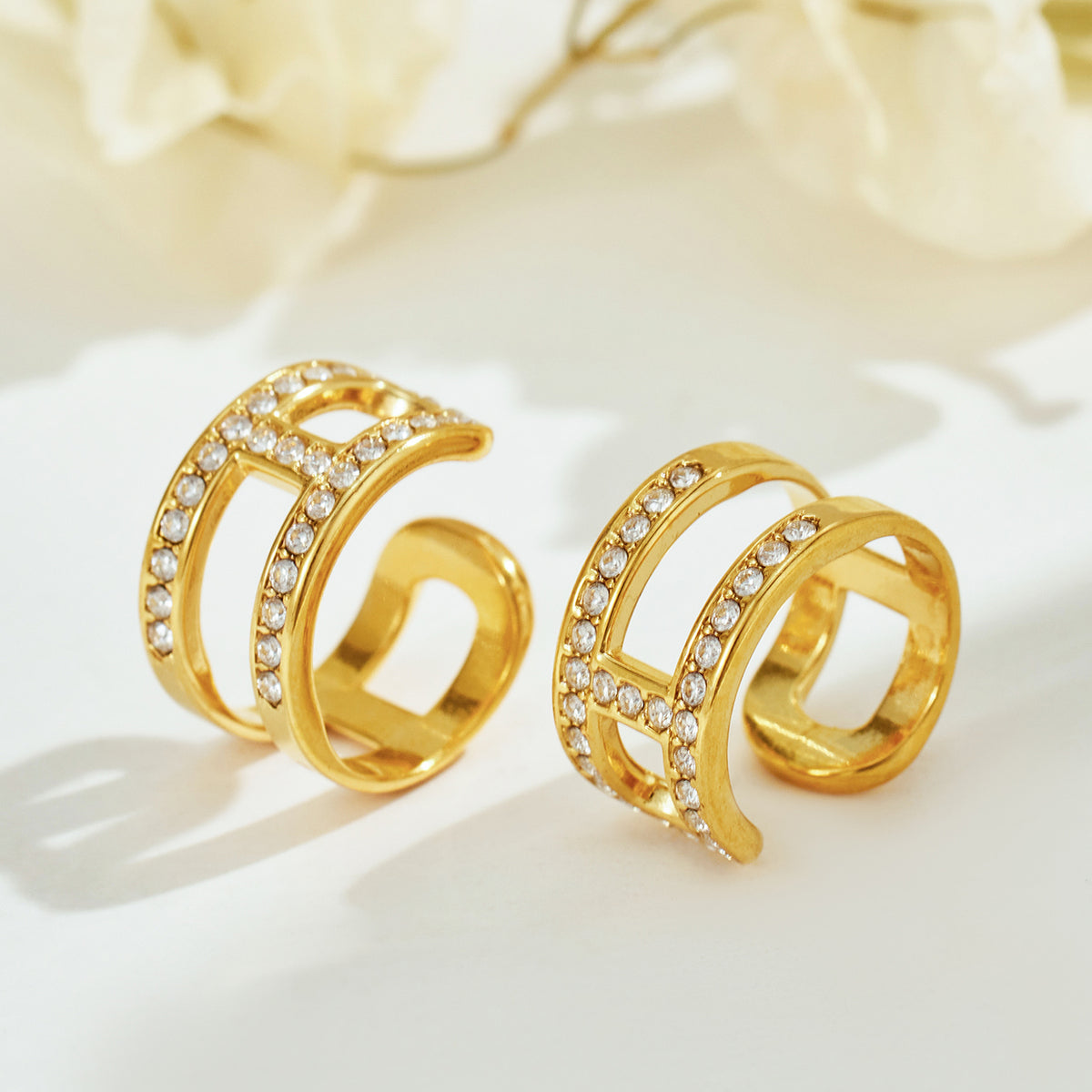 Gold-tone stainless steel rhinestone ear cuffs displayed for wholesale selection
