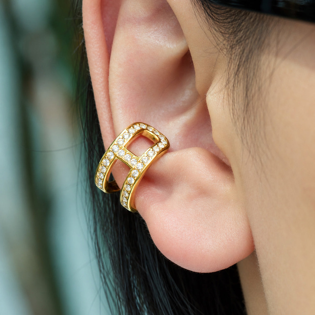 Gold-tone stainless steel non-pierced ear cuff with clear rhinestone accents shown close up