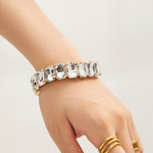 Gold rhinestone stretch bracelet with oversized clear glass stones shown close up on wrist