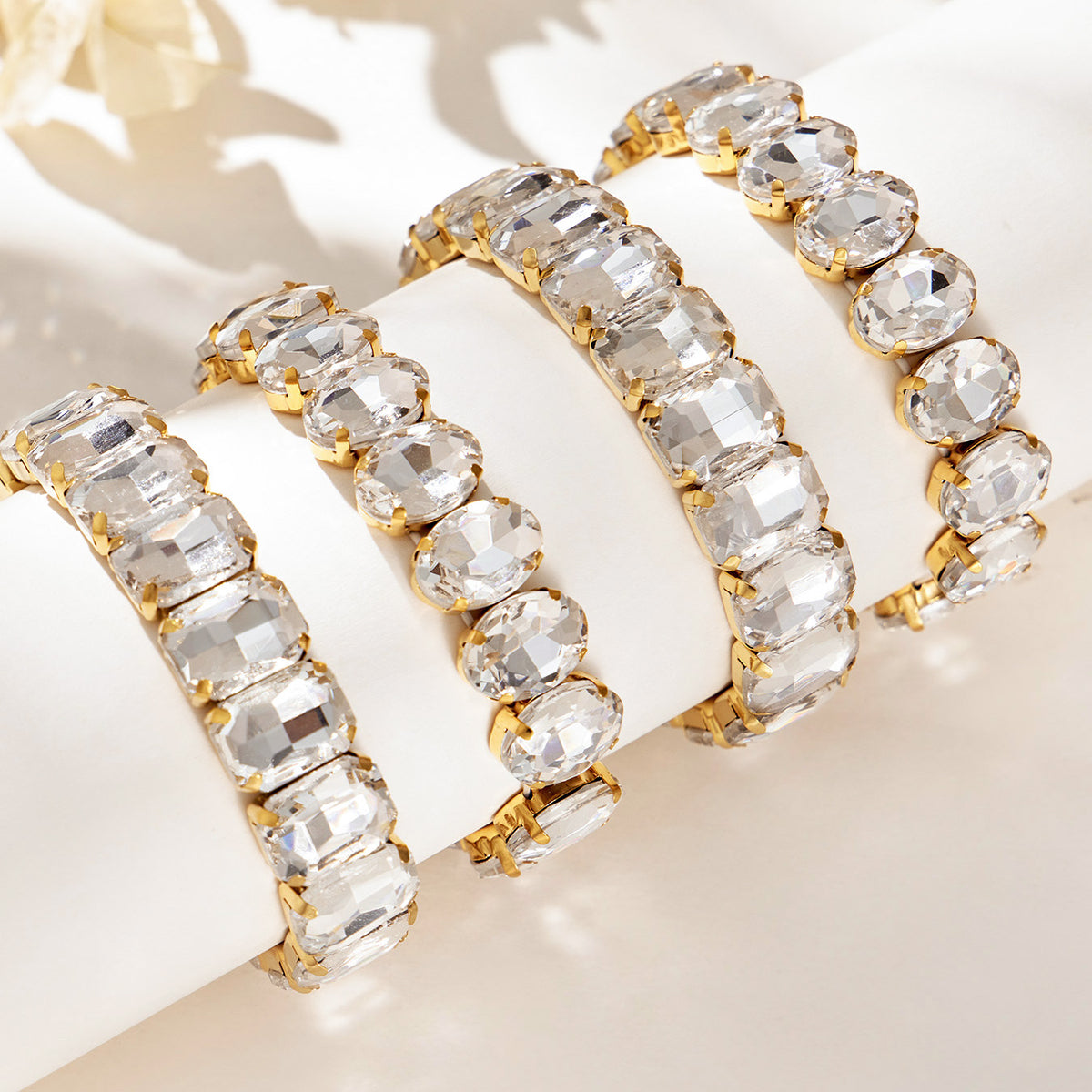 Gold-tone rhinestone stretch bracelets with multiple faceted stone shapes displayed for wholesale selection
