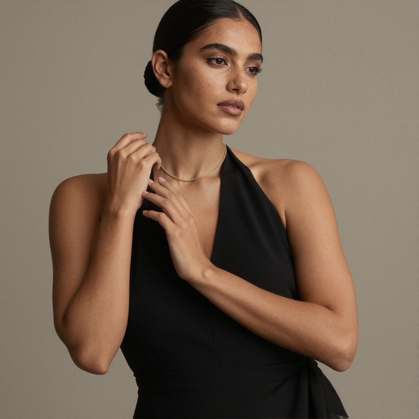 Model wearing gold rope chain necklace with black dress and hoop earrings for minimalist boutique jewelry styling