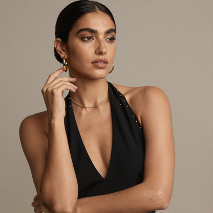 Gold rope chain necklace worn by model in black outfit for evening, everyday and boutique necklace displays