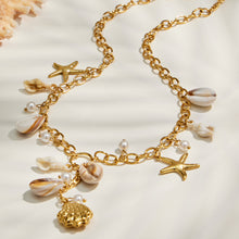 Gold seashell charm necklace displayed flat with multiple ocean-inspired pendants