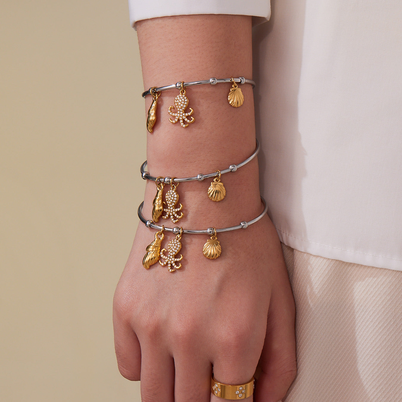Gold & silver ocean shell/octopus bangle stack on wrist, trendy INS accessory
