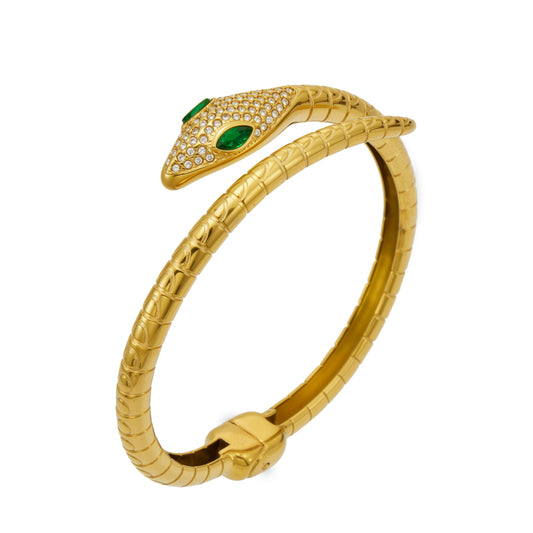Gold snake open bangle with green zircon eyes and clear pavé details on a white background