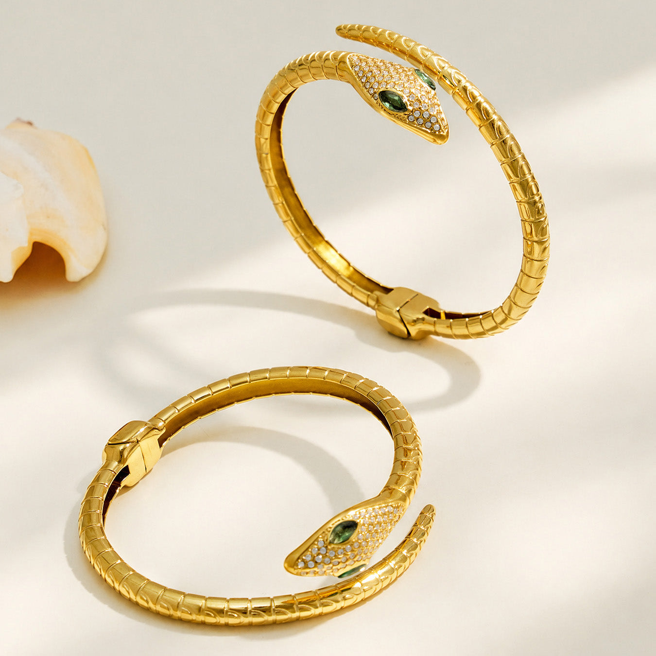 Gold snake open bangle shown from two angles on a light background