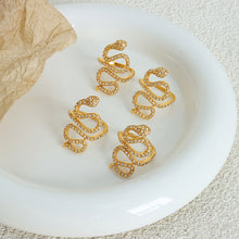 Gold snake cubic zirconia statement ring in a lifestyle jewelry display