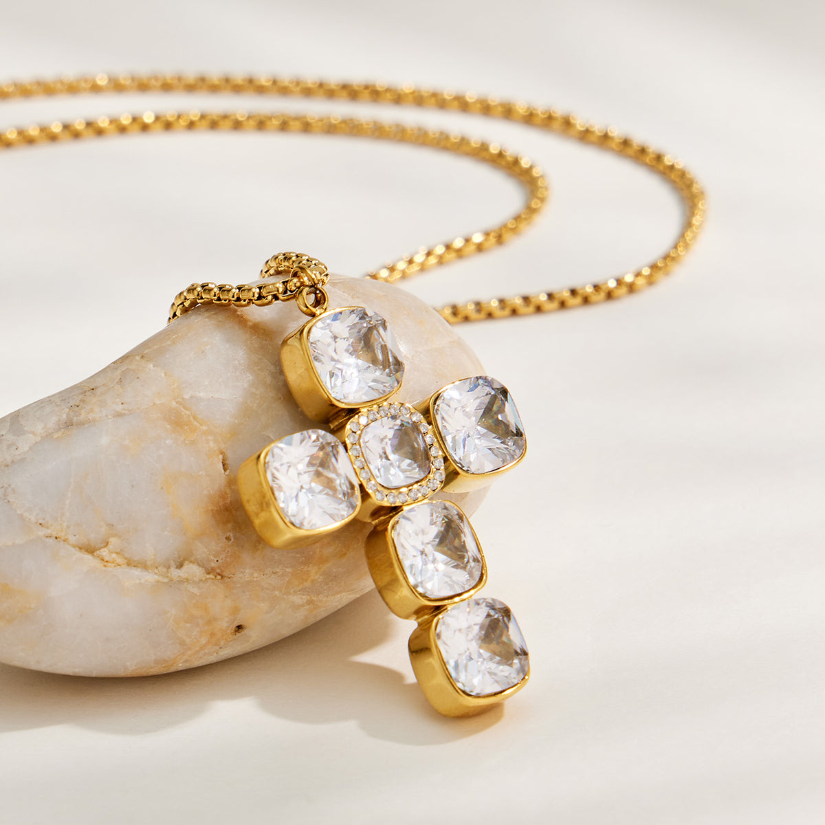 Gold zircon cross pendant with faceted square-stone details