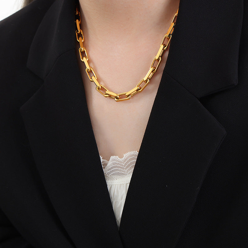 Model wearing a gold stainless steel chunky chain necklace with a black blazer