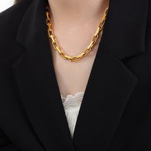 Model wearing a gold stainless steel chunky chain necklace with a black blazer