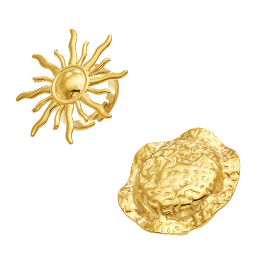 Gold-tone stainless steel statement rings in sun and textured disc designs, showing wavy rays and raised surface details