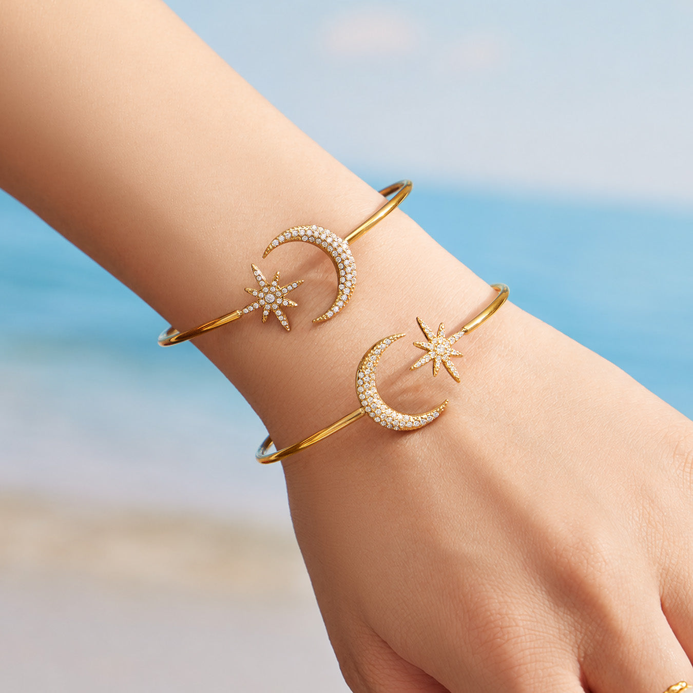 Gold star and moon open cuff bracelet with zircon details worn on a model wrist