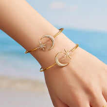 Gold star and moon open cuff bracelet with zircon details worn on a model wrist