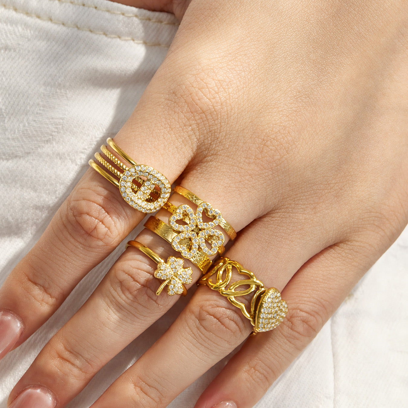 Model wearing gold 316L stainless steel statement rings with clear cubic zirconia accents