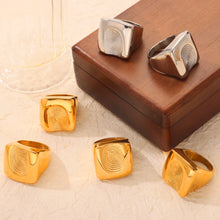 Chunky fingerprint rings in gold and steel finishes displayed with wide sculptural bands