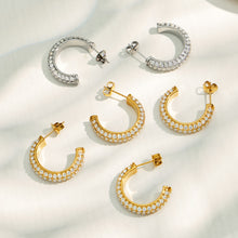 Gold and steel C-shaped cubic zirconia hoop earrings displayed in multiple styles