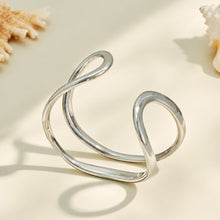 Gold and polished steel double loop cuff bracelets displayed together