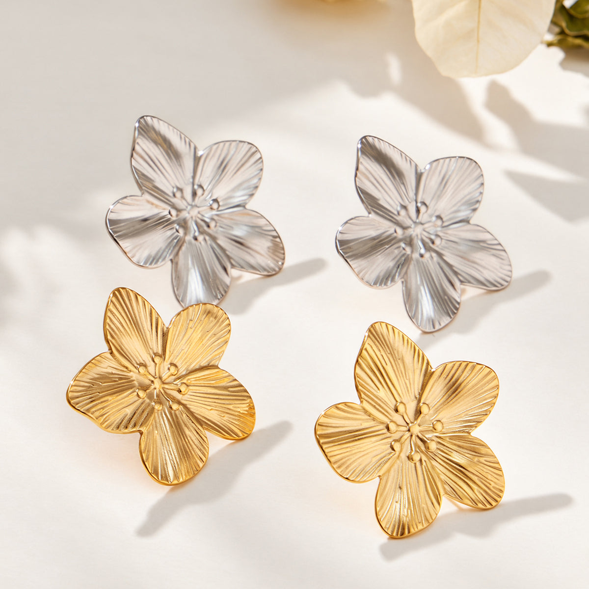Gold-tone and steel-tone flower earrings with textured stainless steel petals