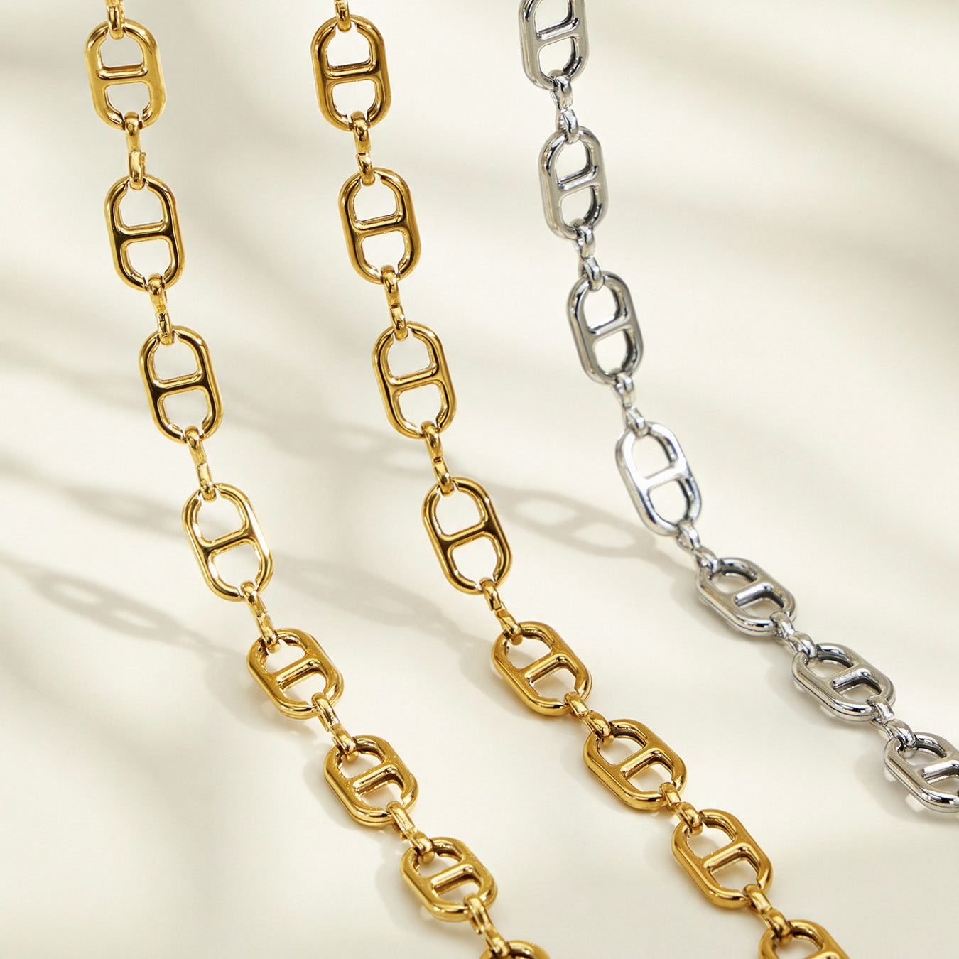 Gold-plated and polished steel mariner chain link finish options displayed together