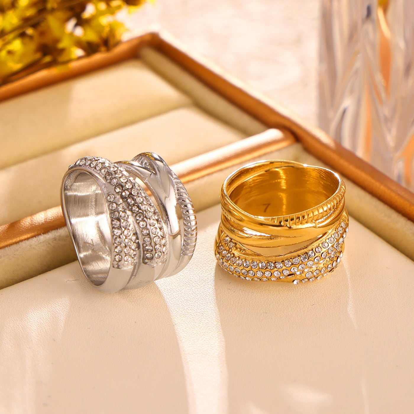 Gold and polished steel multi-row cubic zirconia rings displayed together