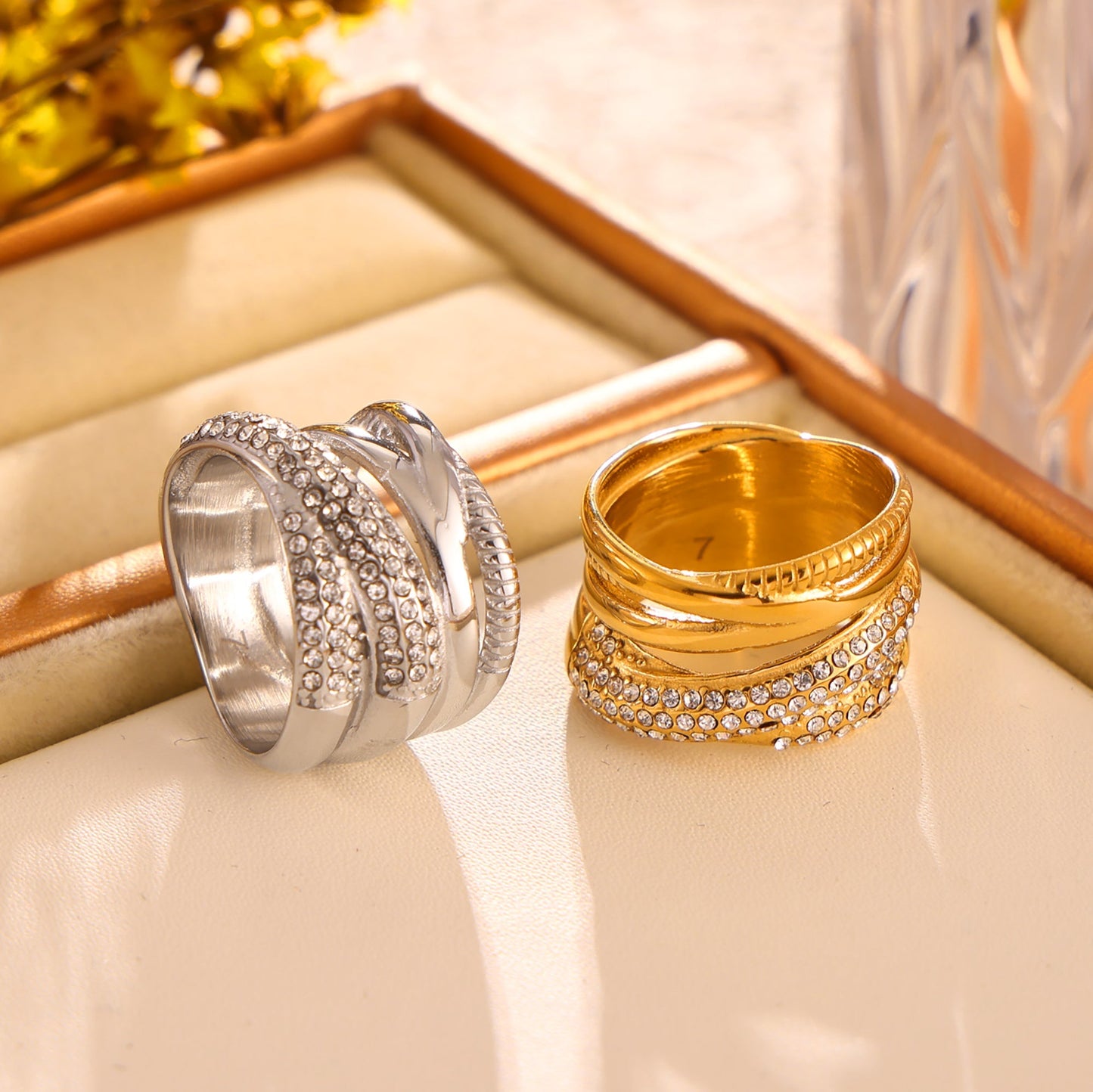 Gold and polished steel multi-row cubic zirconia rings displayed together