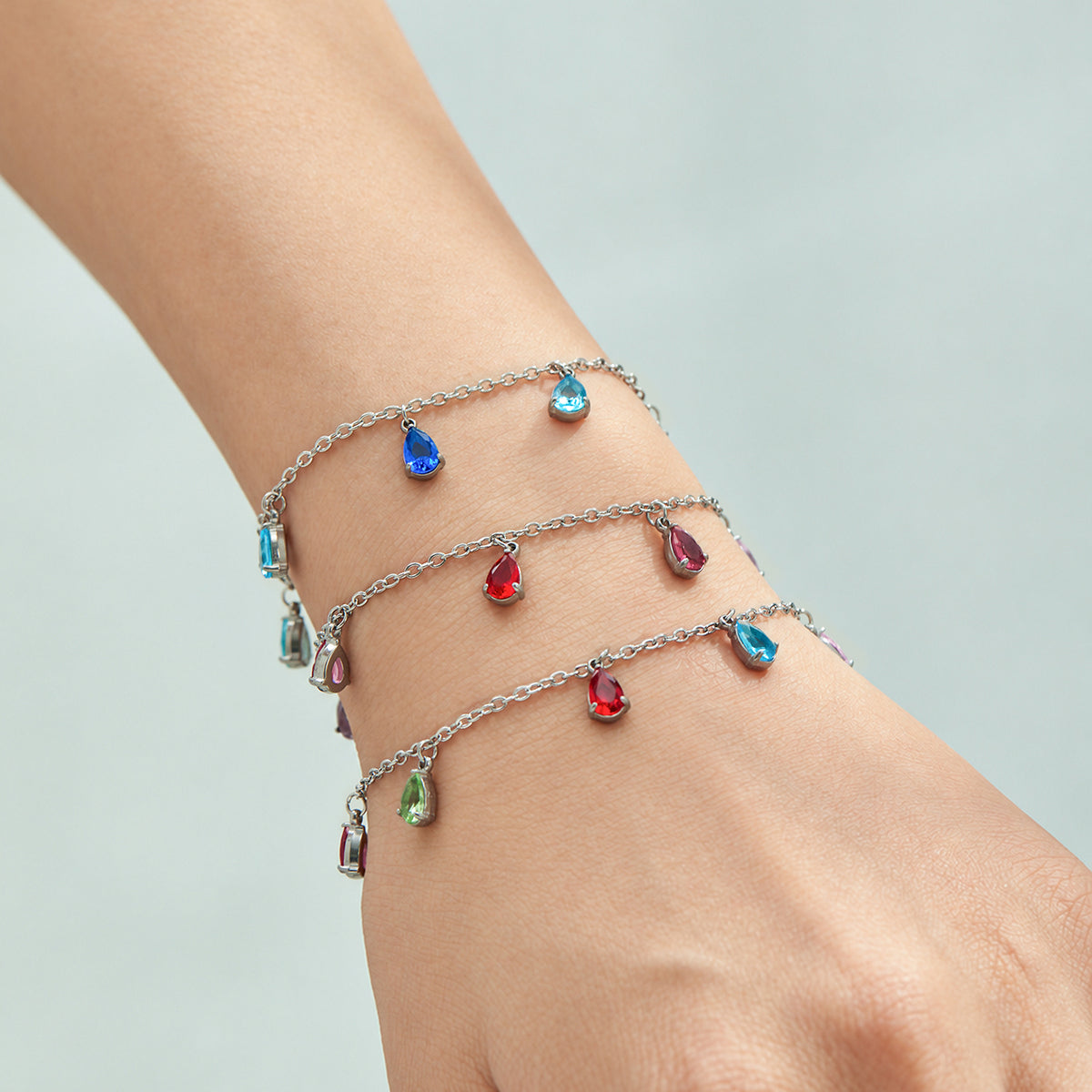 Gold-tone and steel-tone teardrop zircon bracelets styled together