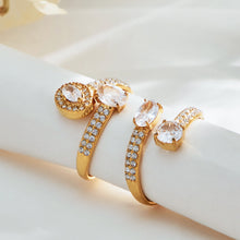 Gold-tone and steel-tone stainless steel CZ open rings displayed together for wholesale selection