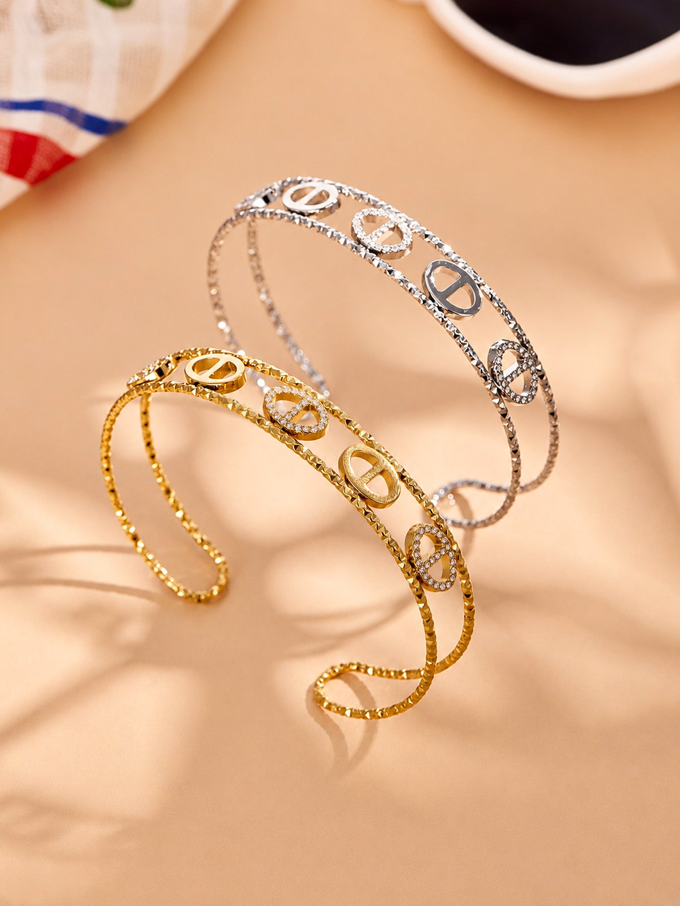 Gold and steel zircon bangle collection showing oval, flower and heart designs in 316L stainless stee