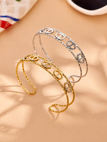 Gold and steel zircon bangle collection showing oval, flower and heart designs in 316L stainless stee
