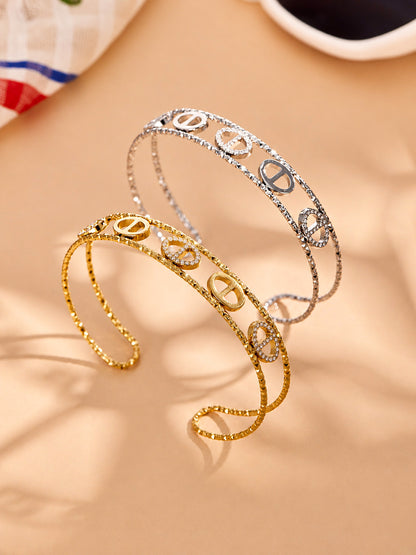 Gold and steel zircon bangle collection showing oval, flower and heart designs in 316L stainless stee