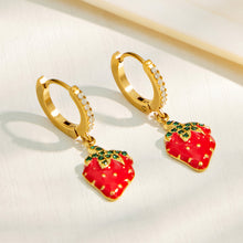 Gold strawberry charm huggie earrings displayed together on a soft neutral background