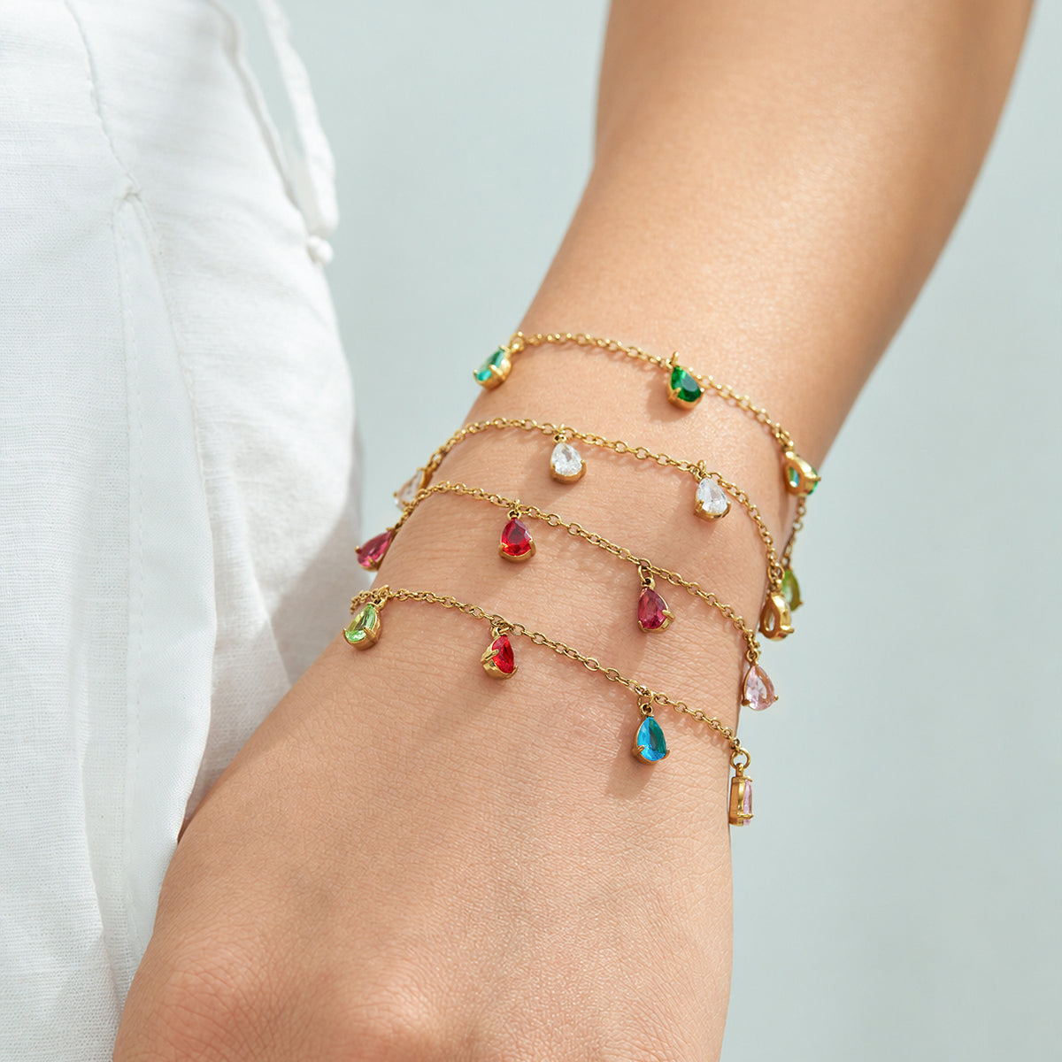 Gold-tone teardrop zircon bracelets in several colors styled on the wrist