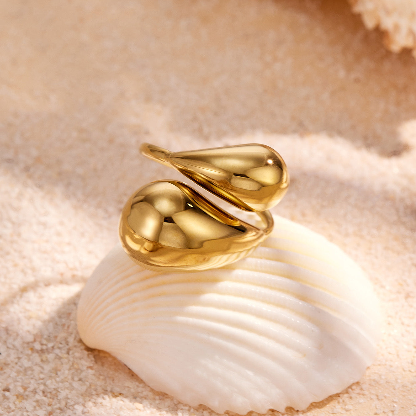 Gold teardrop open ring flat lay in 316L stainless steel with sculptural statement silhouette