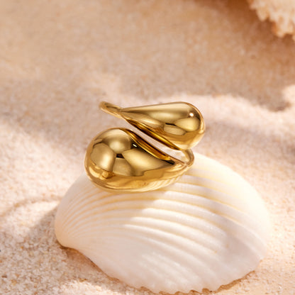 Gold teardrop open ring flat lay in 316L stainless steel with sculptural statement silhouette